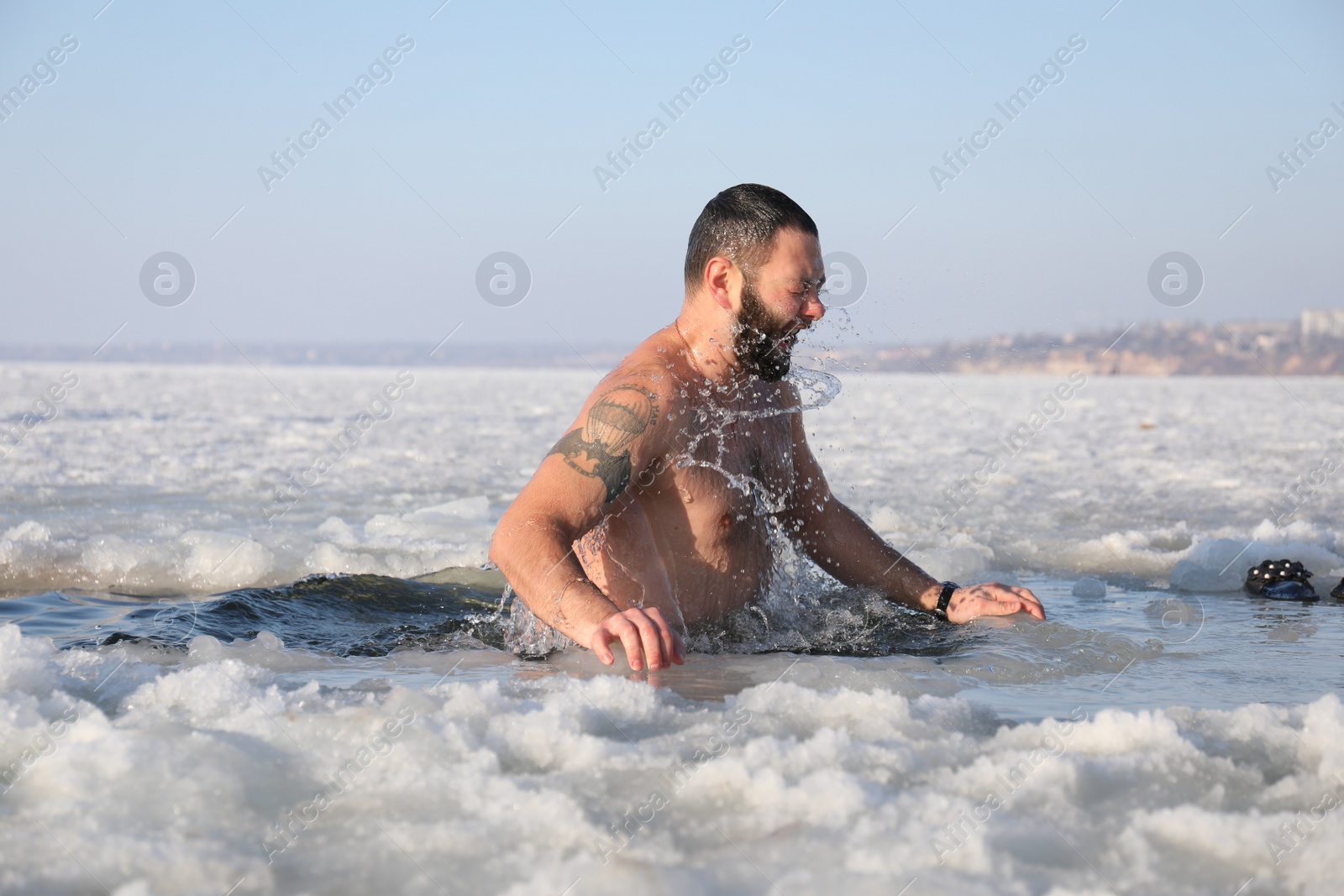 Photo of MYKOLAIV, UKRAINE - JANUARY 06, 2021: Man immersing in icy water on winter day