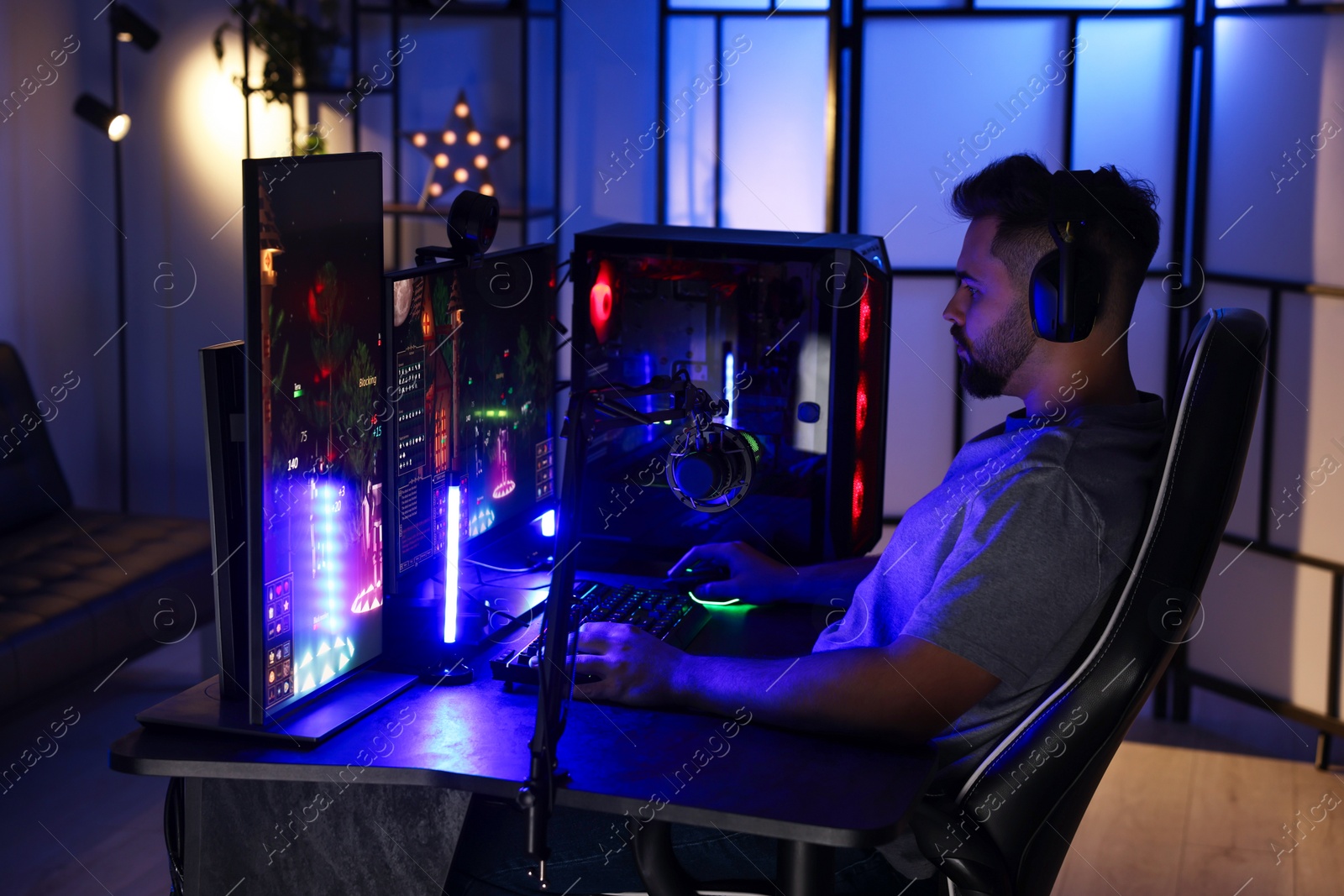 Photo of Man playing video games on computer at table indoors