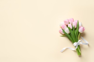 Photo of Beautiful pink spring tulips on beige background, top view. Space for text