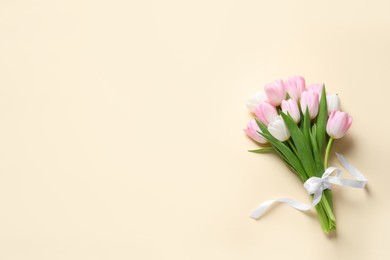 Beautiful pink spring tulips on beige background, top view. Space for text