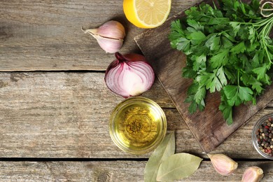 Photo of Board with fresh parsley, peppercorns and other products on wooden table, flat lay. Space for text