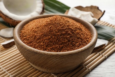 Natural coconut sugar in bowl on white wooden table