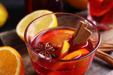 Photo of Glass of aromatic punch drink on table, closeup