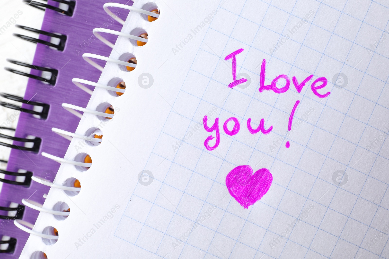 Photo of Notebook page with written words I LOVE YOU and heart, top view