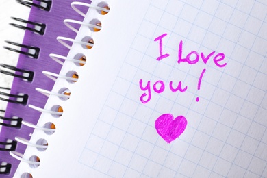 Notebook page with written words I LOVE YOU and heart, top view