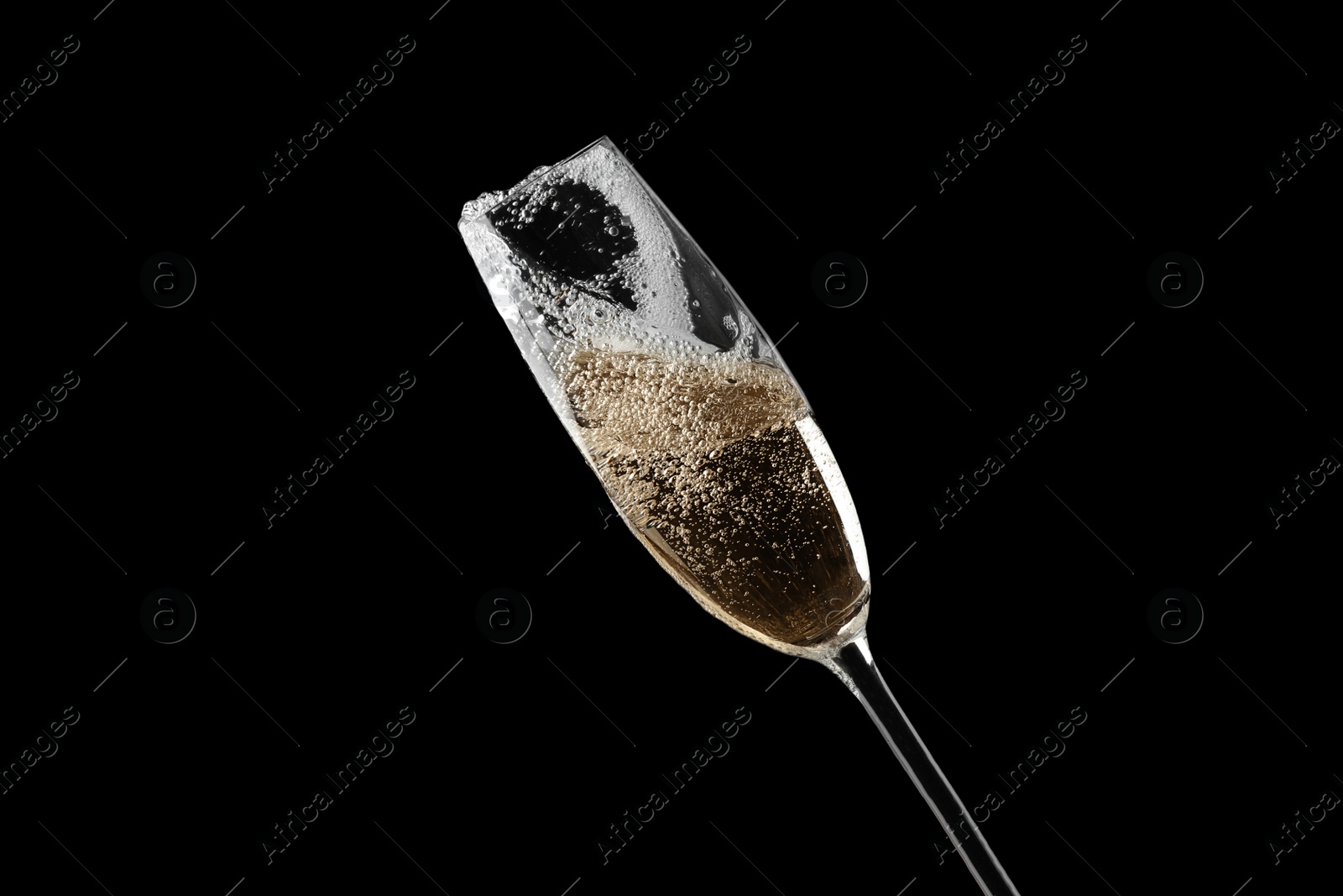 Photo of Glass of fizzy champagne on black background, closeup