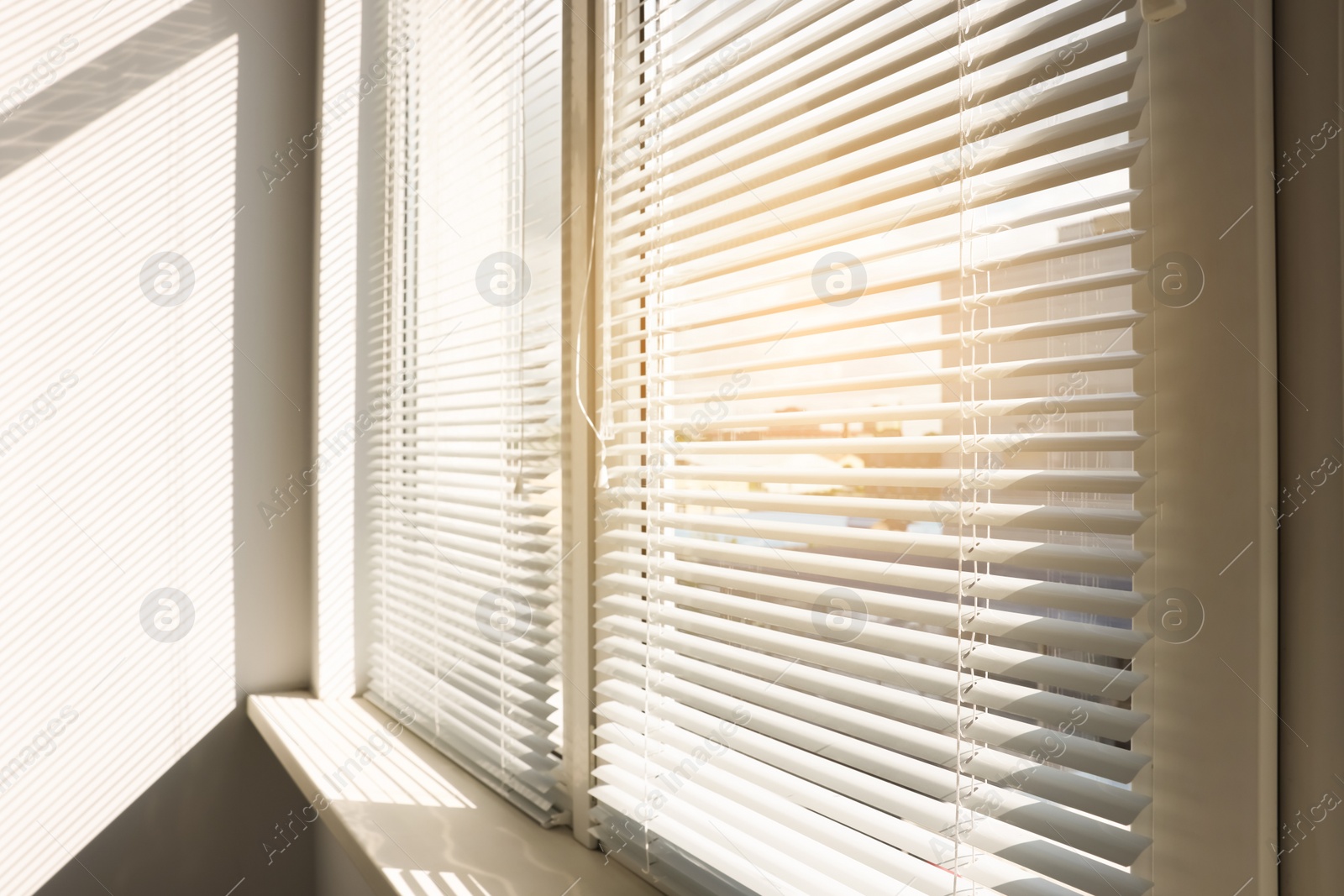 Photo of Stylish window with horizontal blinds in room