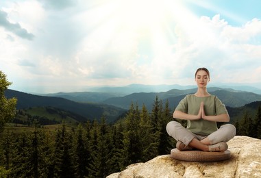 Image of Woman meditating in mountains at sunrise, space for text