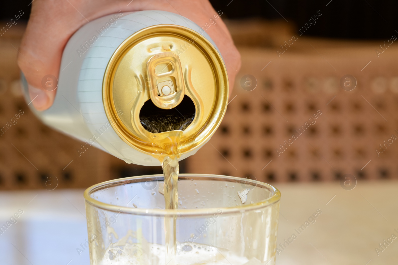 Photo of Man pouring beer from can into glass at table, closeup. Space for text