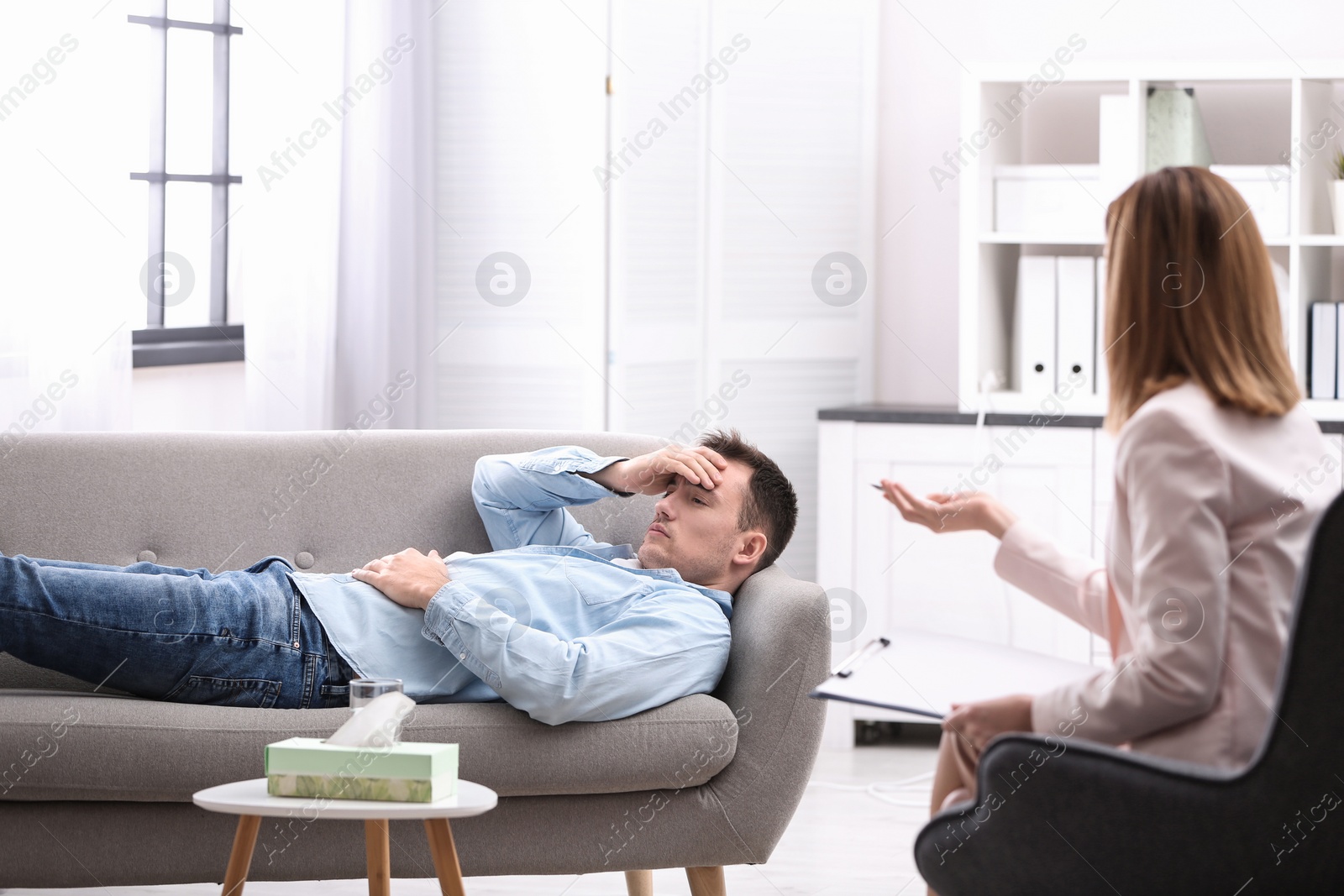 Photo of Psychotherapist working with young man in office