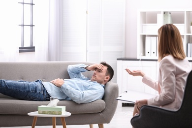 Photo of Psychotherapist working with young man in office