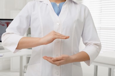 Photo of Young gynecologist holding something in clinic, closeup