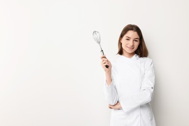 Photo of Professional chef with whisk on light background. Space for text