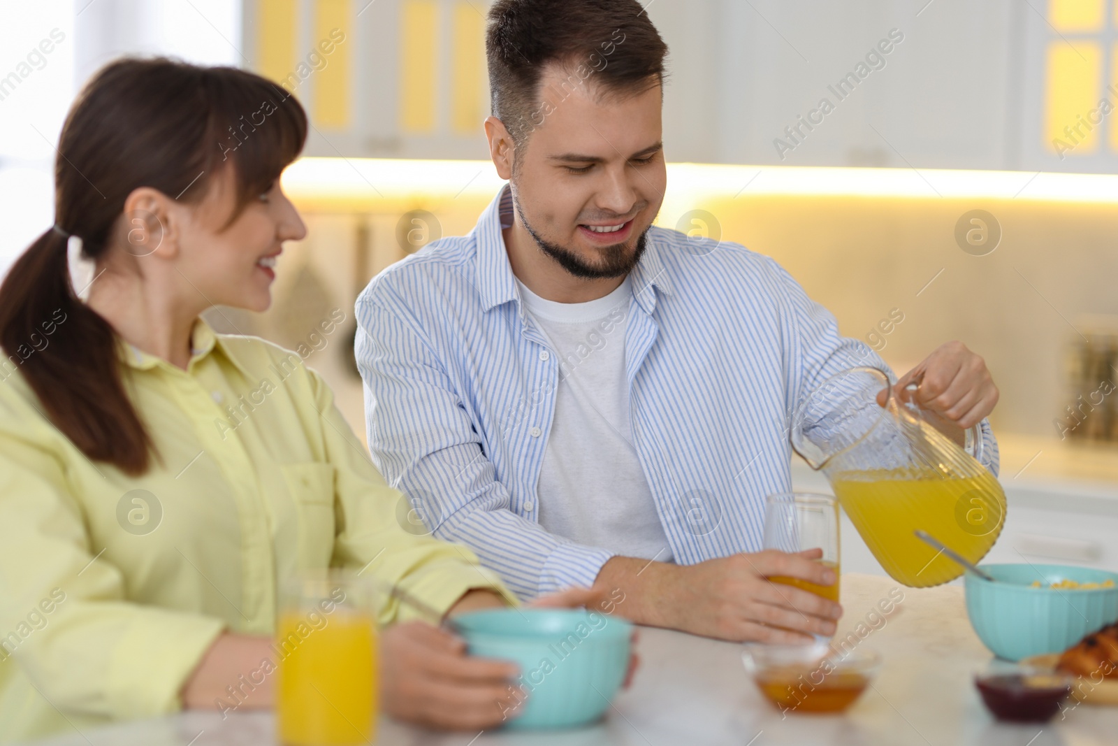 Photo of Happy couple having tasty breakfast at home