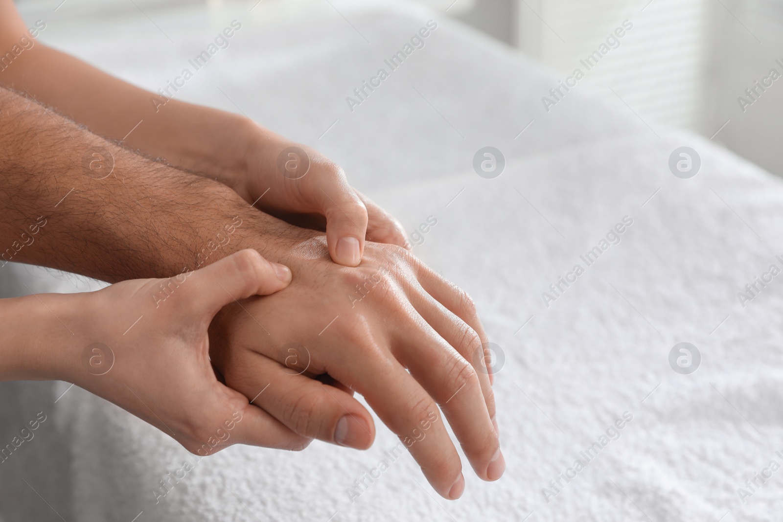 Photo of Man receiving hand massage in wellness center, closeup