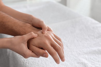 Photo of Man receiving hand massage in wellness center, closeup