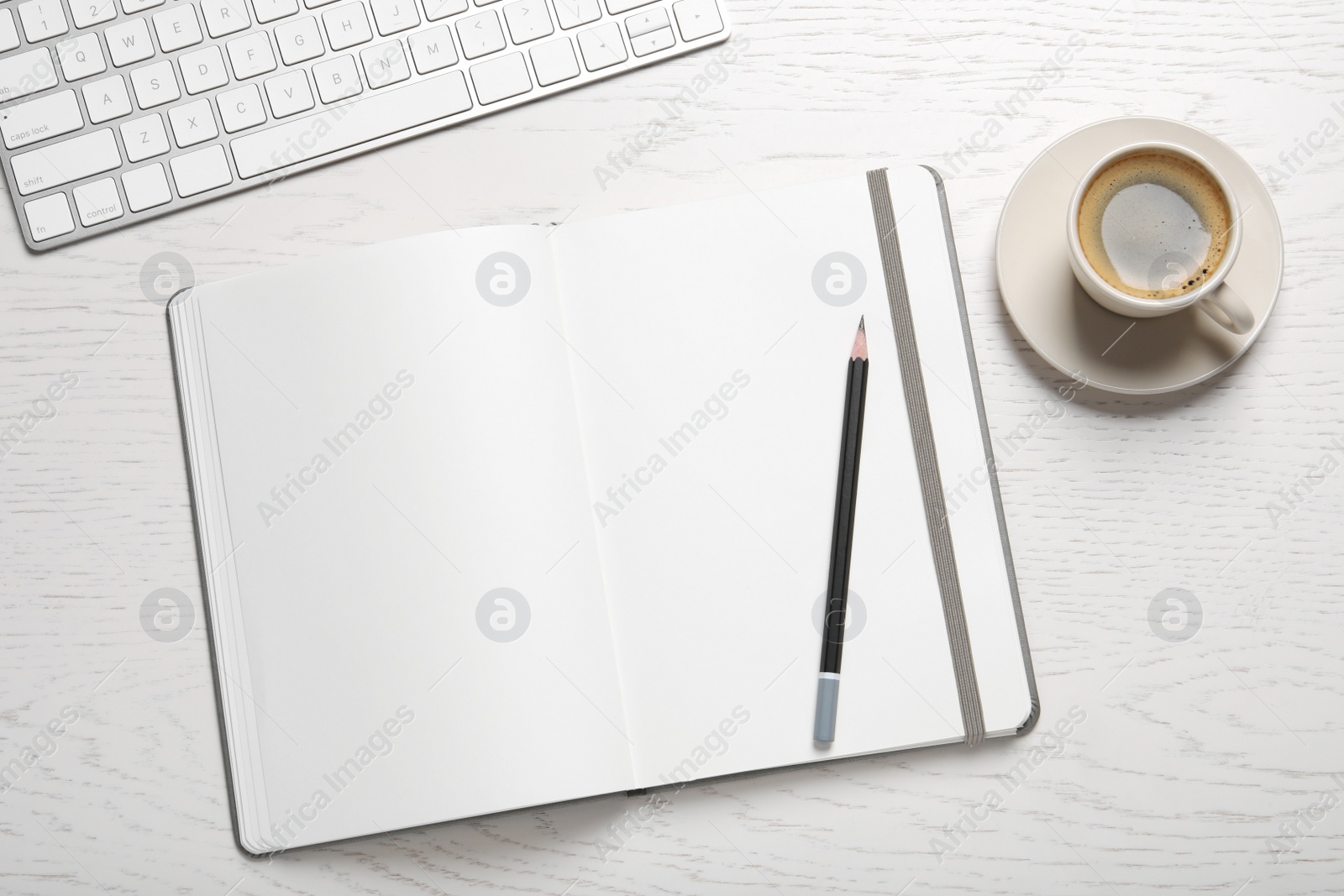 Photo of Open blank notebook, pencil, coffee and keyboard on white wooden table, flat lay