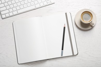 Photo of Open blank notebook, pencil, coffee and keyboard on white wooden table, flat lay