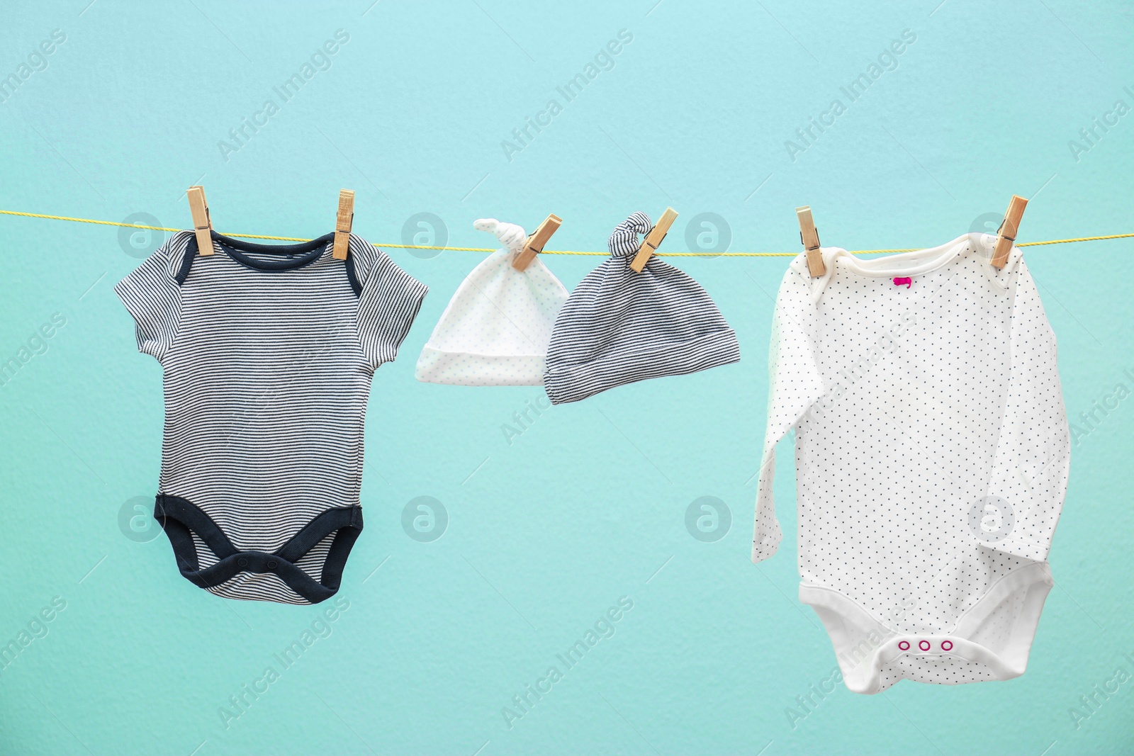 Photo of Children's clothes on laundry line against color background