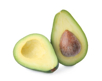 Photo of Halves of ripe avocado with pit on white background