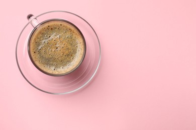 Photo of Aromatic coffee in cup on pink background, top view. Space for text