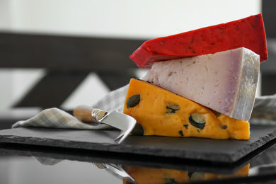 Photo of Different delicious cheeses and knife on table, closeup