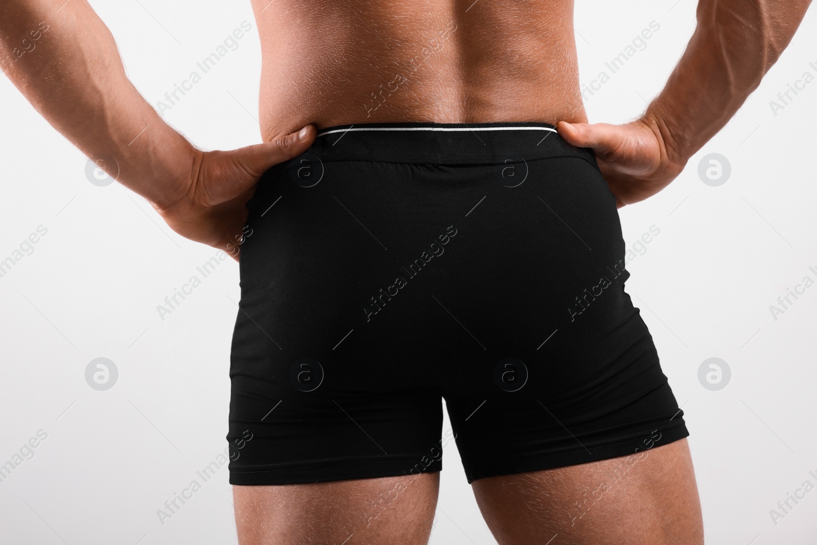 Photo of Young man is stylish black underwear on light grey background, closeup