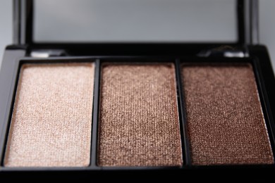 Beautiful eyeshadow palette on light gray background, closeup. Professional cosmetic product