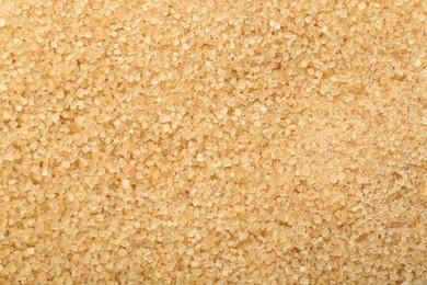 Granulated brown sugar as background, top view