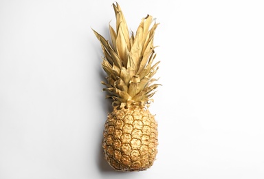 Painted golden pineapple on white background, top view. Creative concept