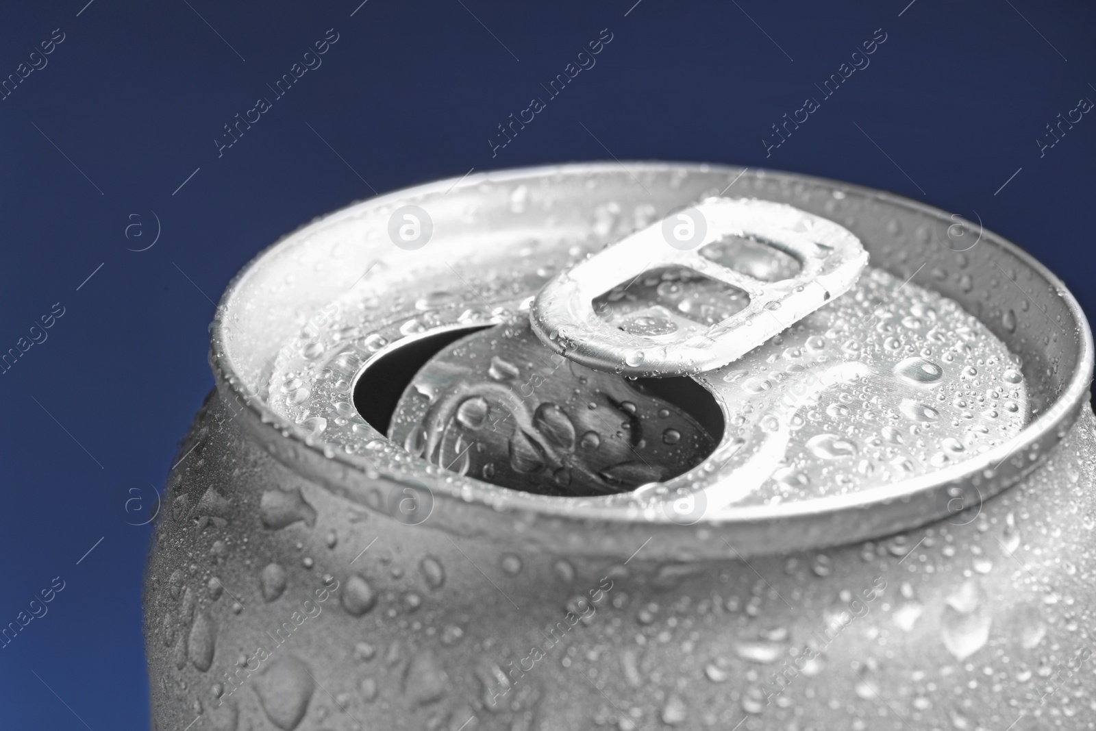 Photo of Wet open can on blue background, closeup