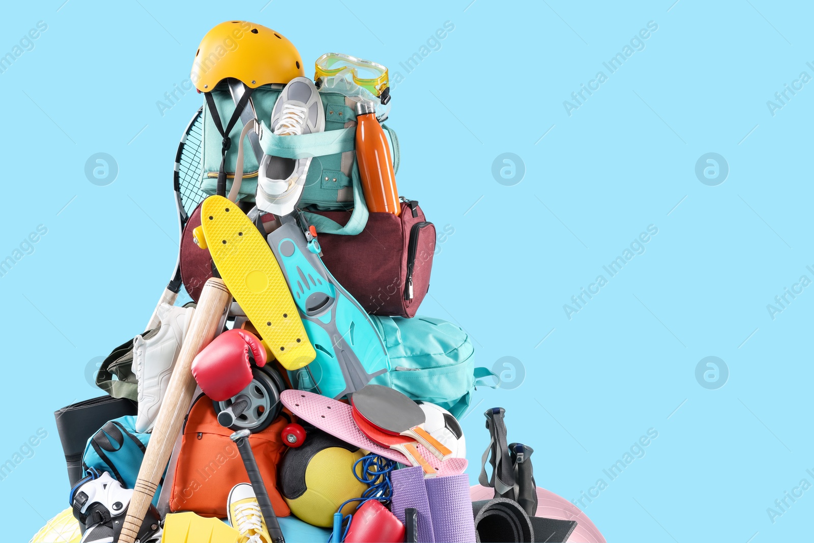 Photo of Many different sports equipment on light blue background