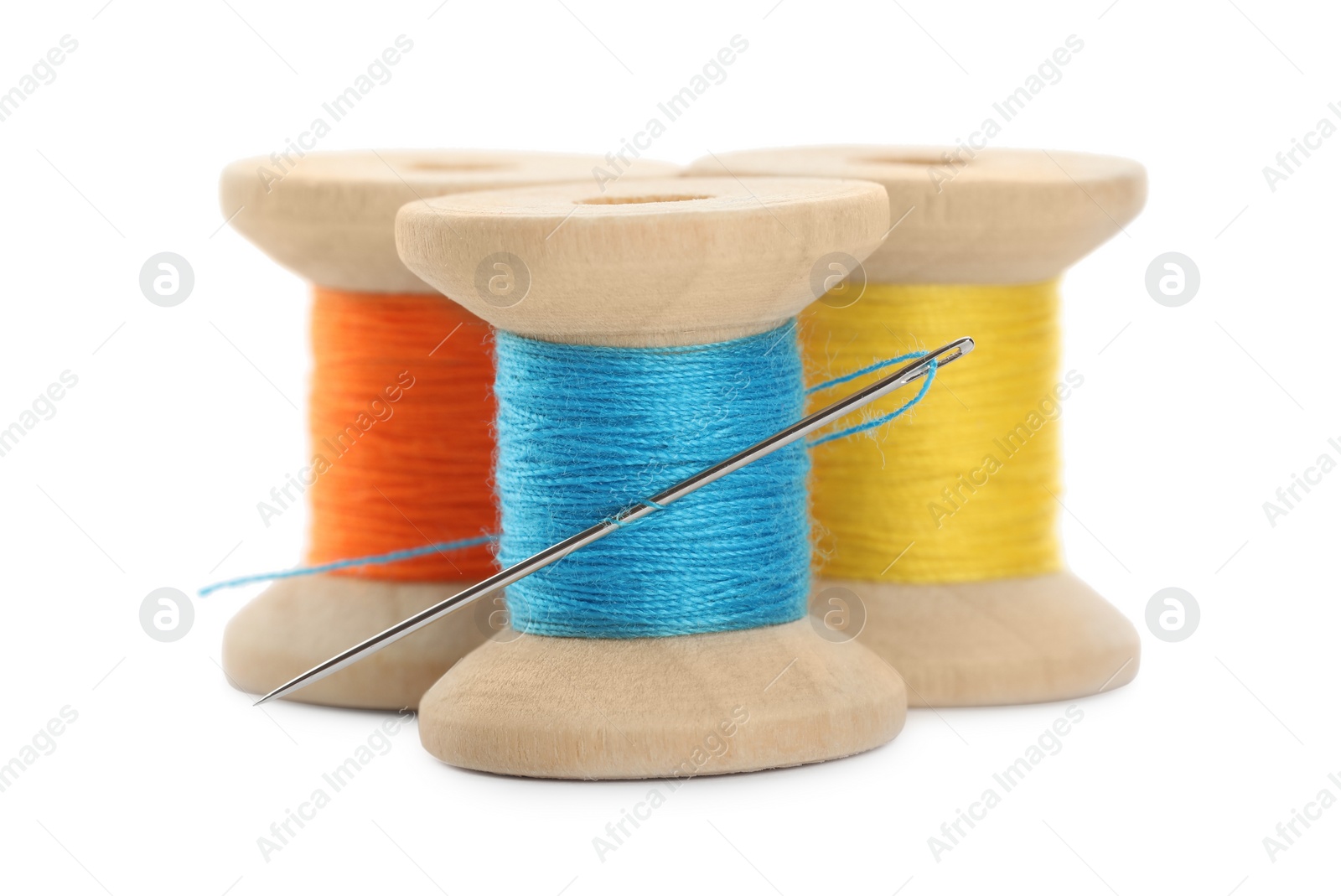 Photo of Different colorful sewing threads with needle on white background, closeup