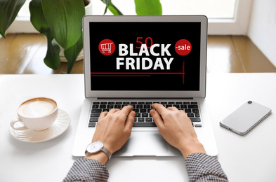 Image of Black Friday. Woman shopping online using laptop at table, closeup