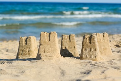 Photo of Beautiful sand castles on beach near sea