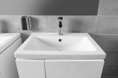 Photo of Beautiful clean sink near mirror in public toilet
