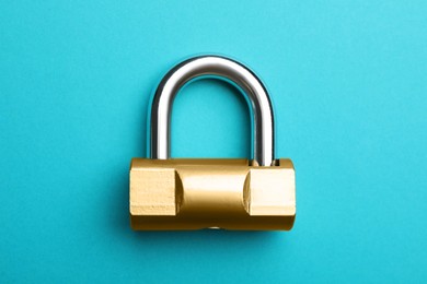 Photo of Modern padlock on light blue background, top view