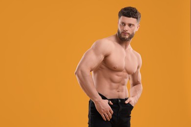Photo of Handsome muscular man on orange background, space for text. Sexy body