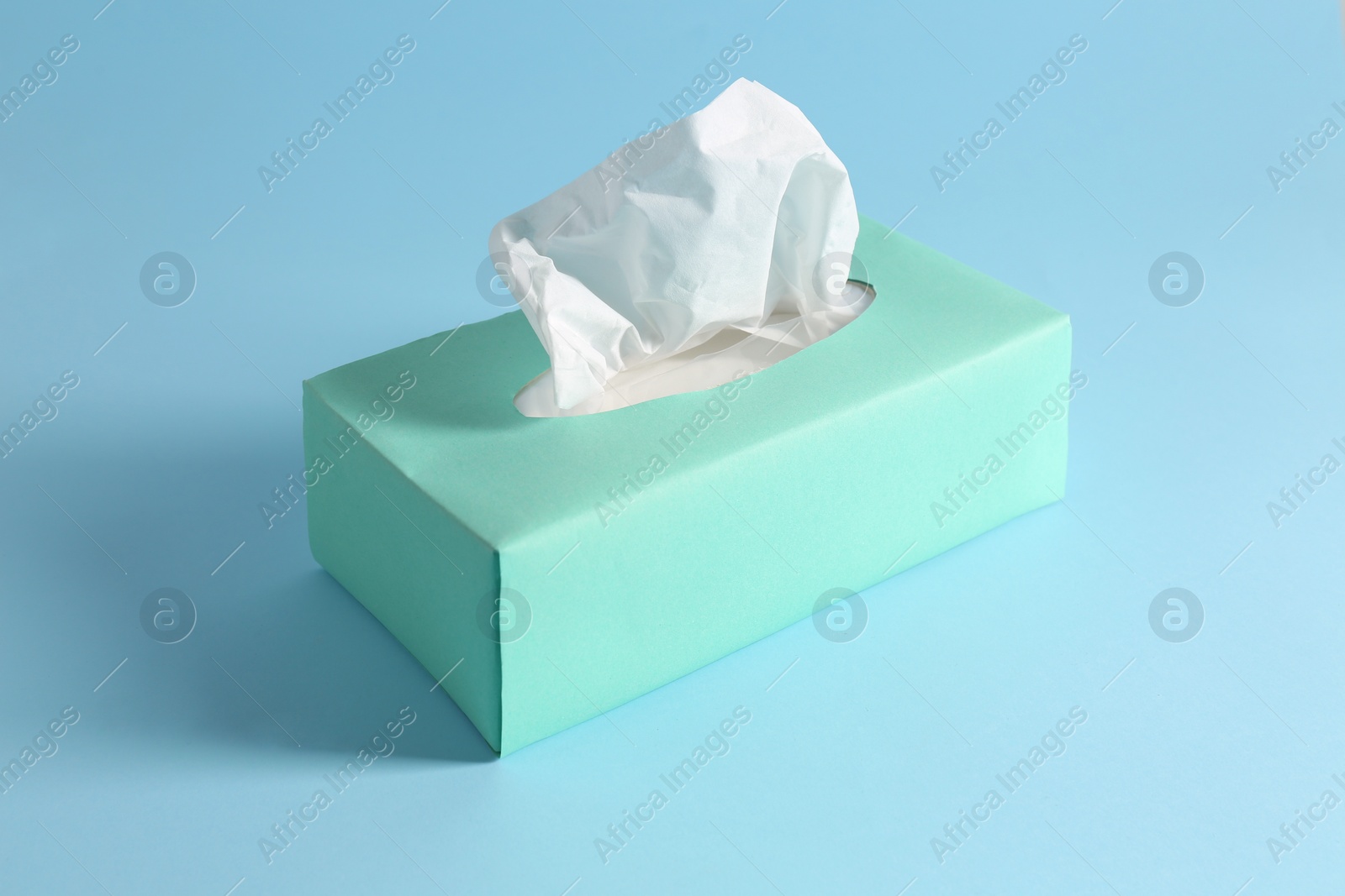 Photo of Box of paper tissues on light blue background