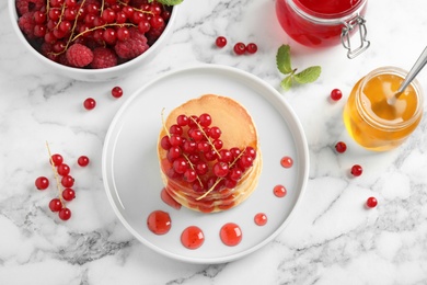 Photo of Tasty pancakes with berries on white marble table, flat lay