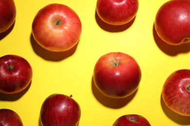 Photo of Ripe red apples on yellow background, flat lay