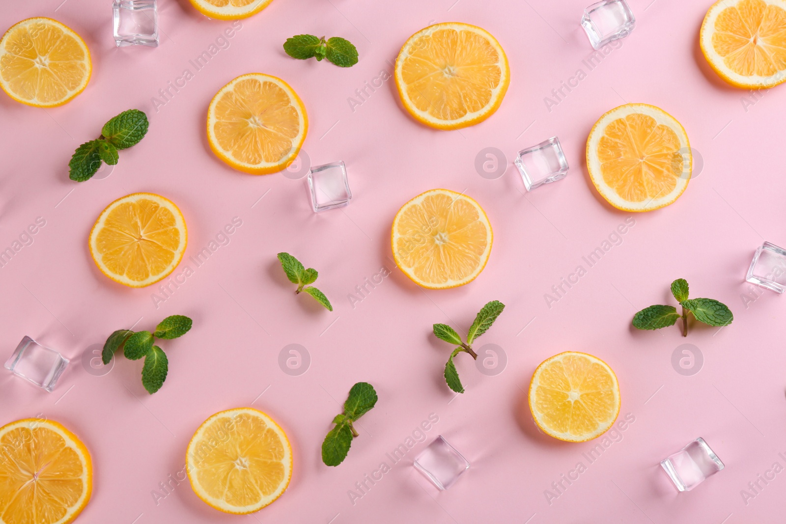 Photo of Lemonade layout with juicy lemon slices, mint and ice cubes on pink background, top view