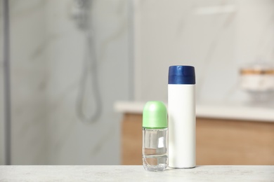 Photo of Different deodorants on table in bathroom, space for text