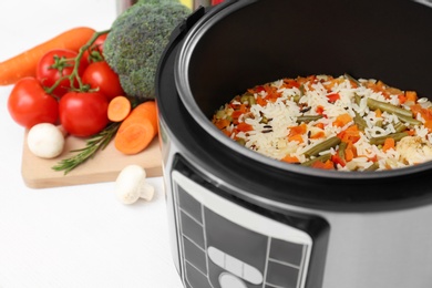 Photo of Prepared rice with vegetables in multi cooker on table, closeup