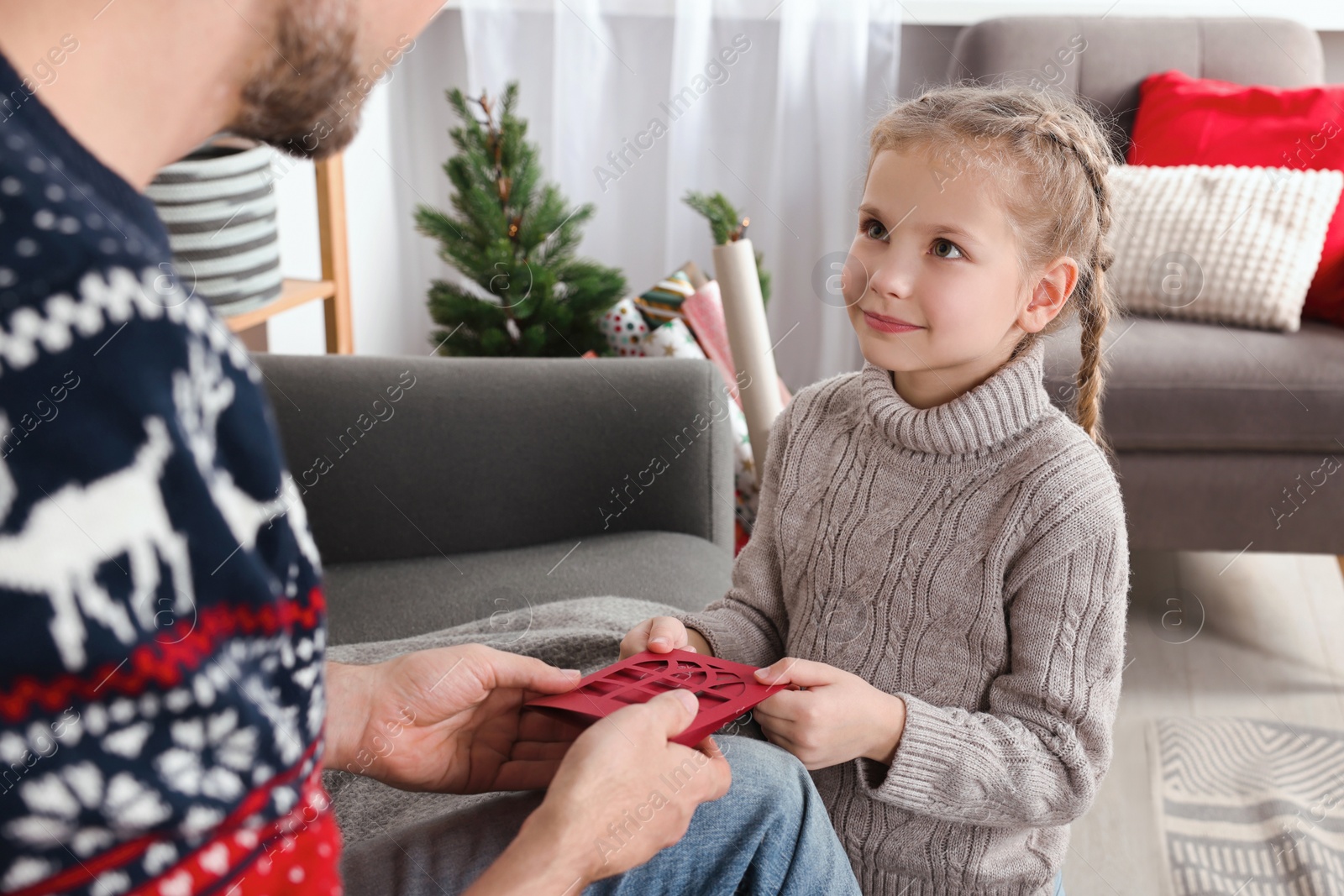 Photo of Man receiving greeting card from his daughter at home