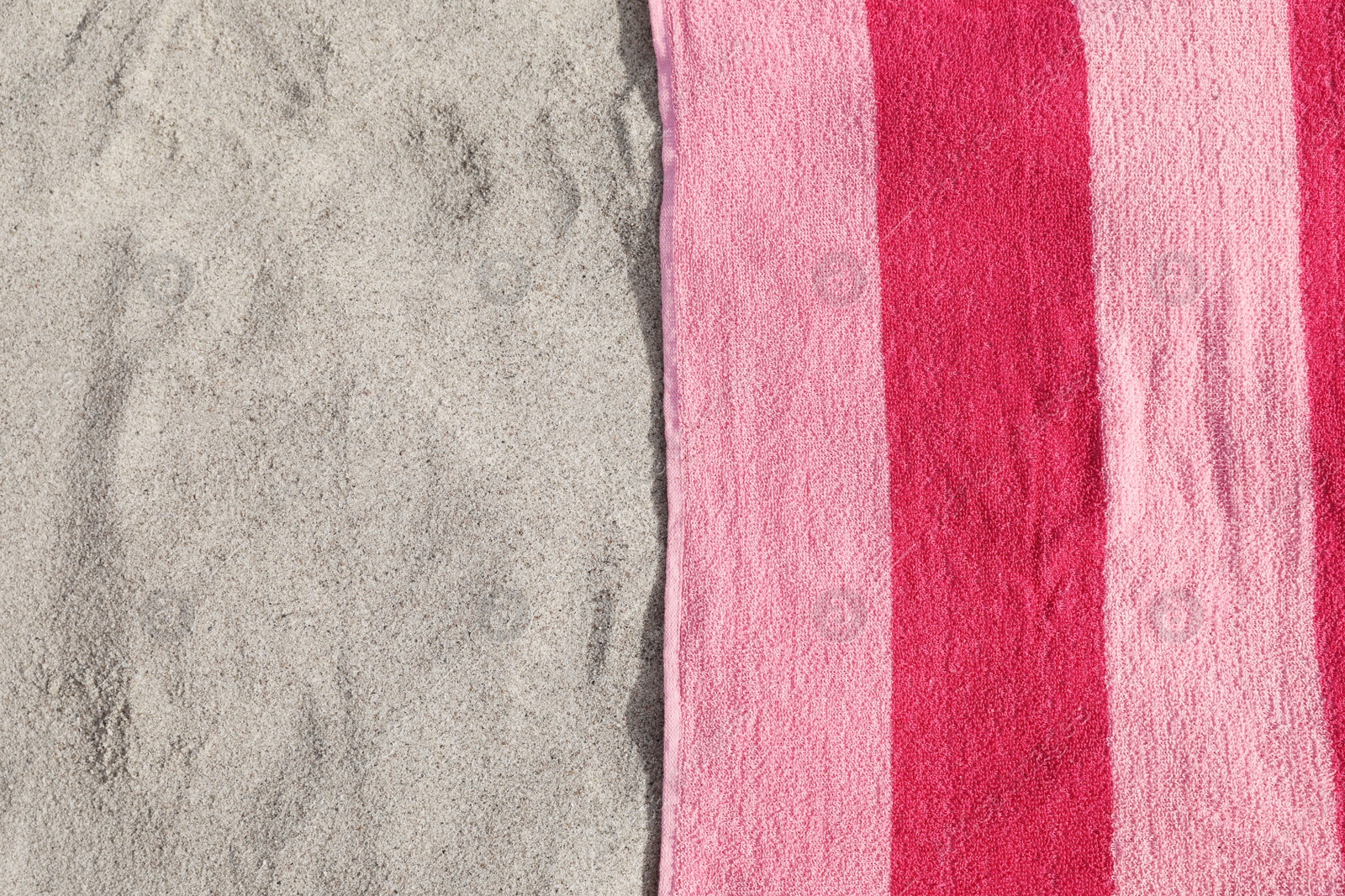 Photo of Soft pink beach towel on sand, top view. Space for text