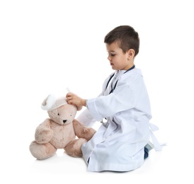 Cute child playing doctor with stuffed toy on white background