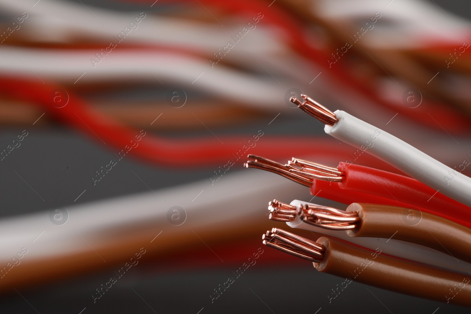 Photo of New colorful electrical wires on blurred background, closeup. Space for text