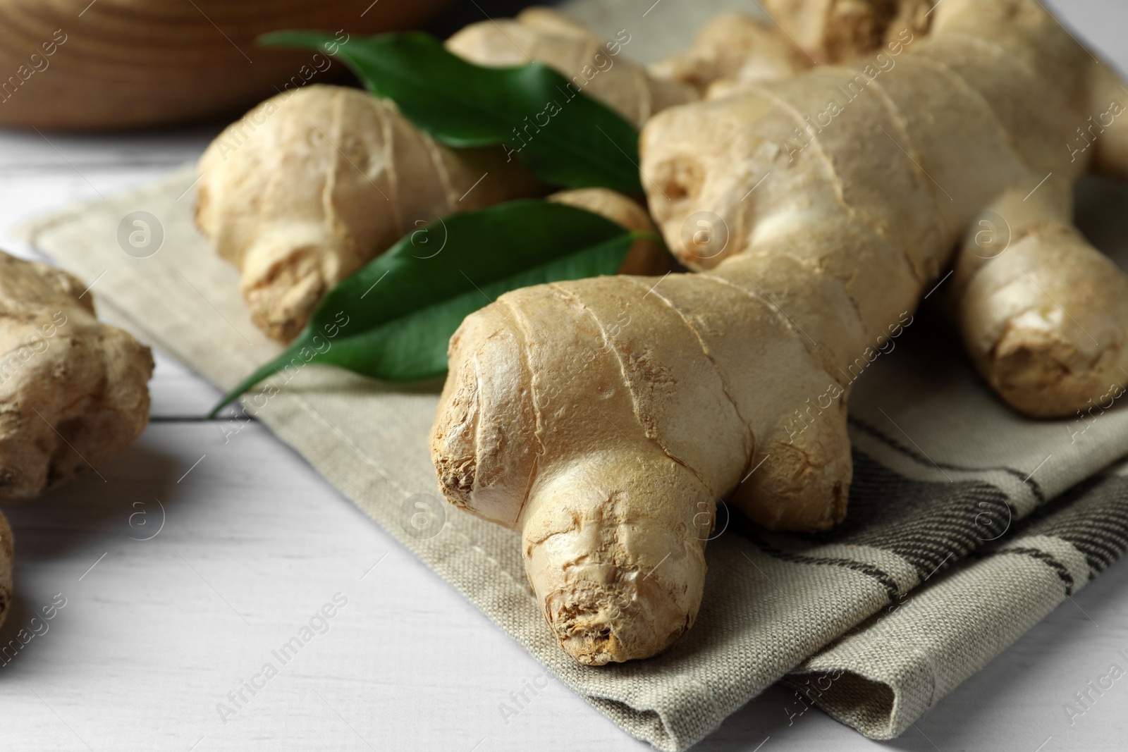 Photo of Fresh ginger with leaves on white wooden table