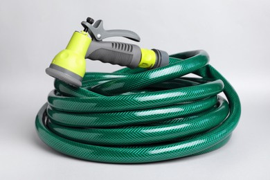 Watering hose with sprinkler on light grey background